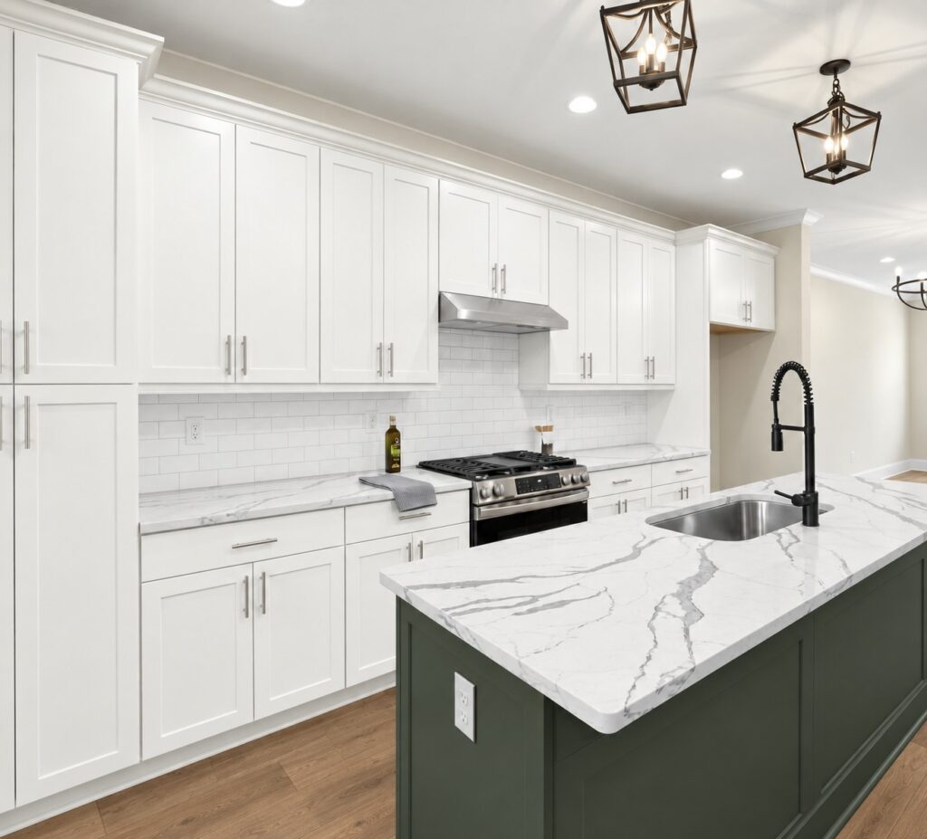 Kitchen with white cabinets and green island